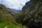 Pouring of natural Asturian cider made fromÂ fermented apples from green bottle and high height with view on Covadonga lake and